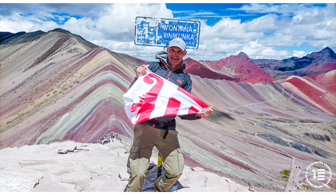 reisender mit flagge auf einem berg in südamerika