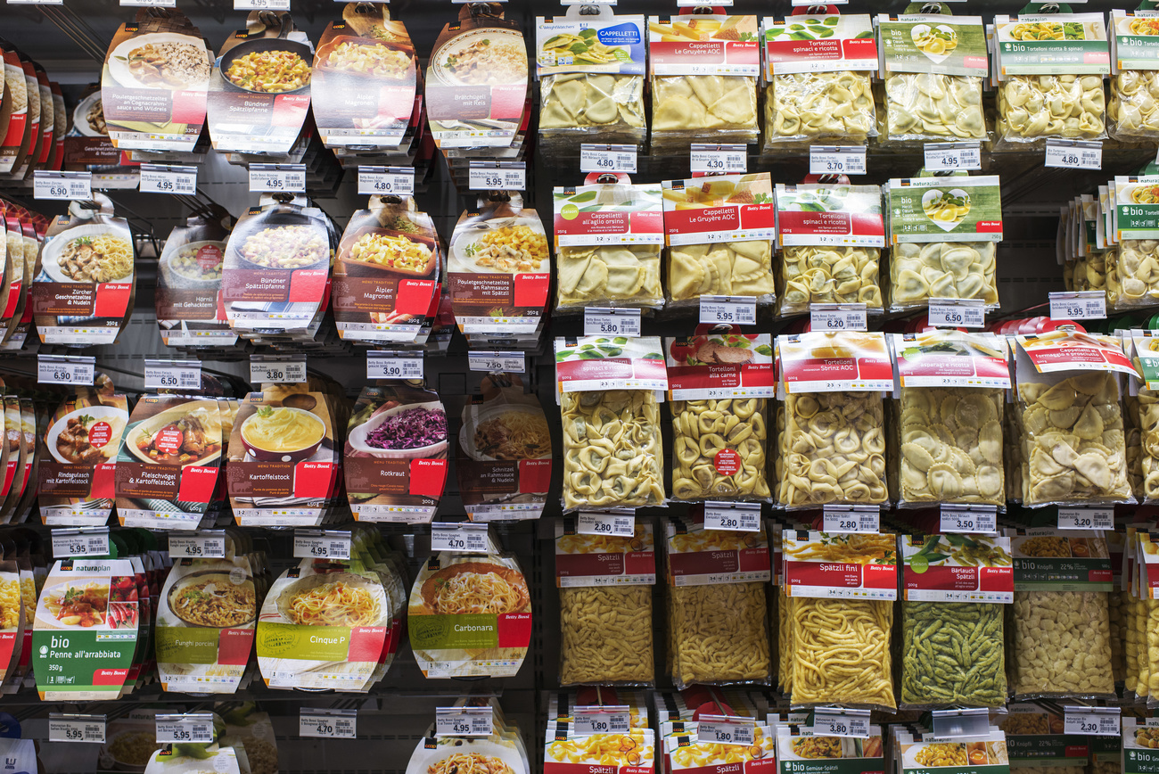 Packs of ready meals hang in rows at a supermarket.