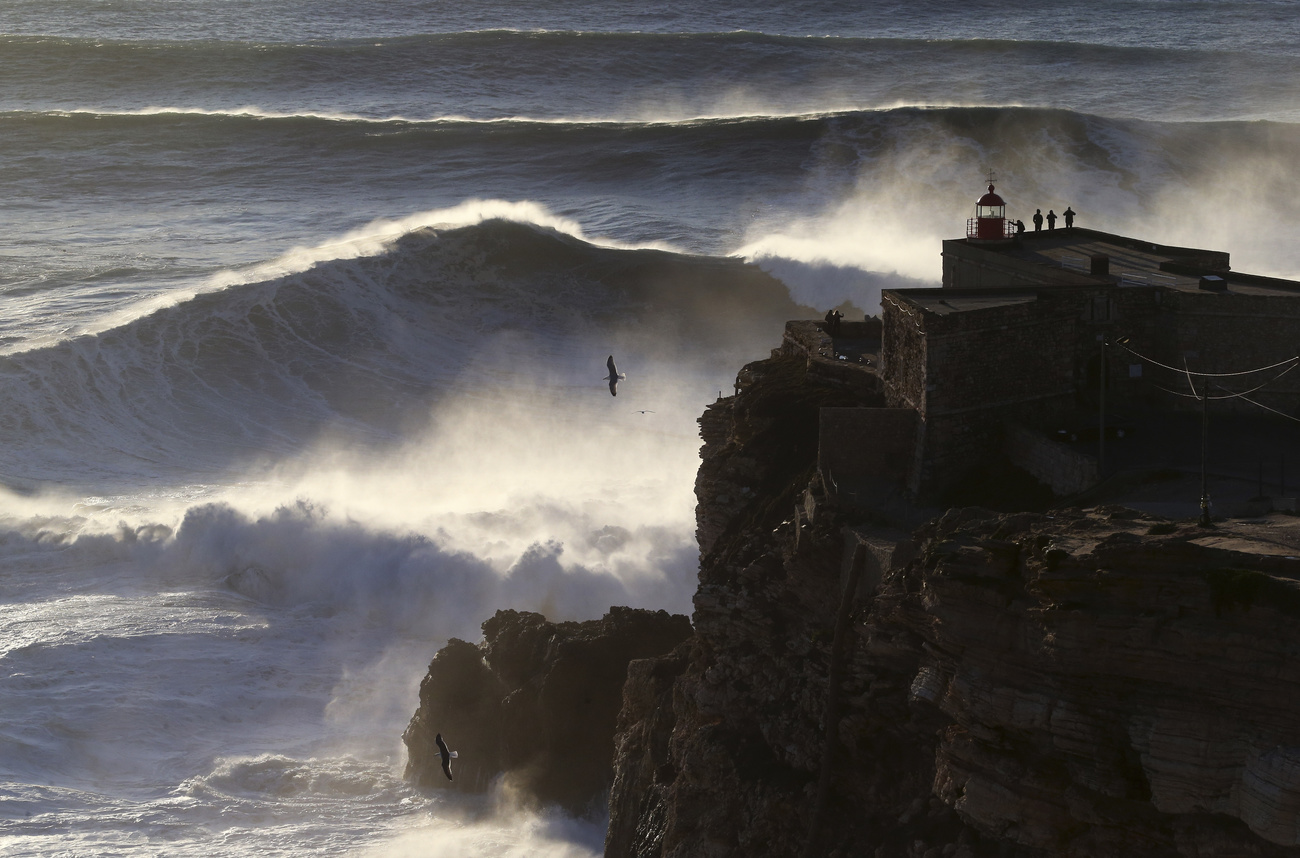 People on the top of the Nazare lighthouse watch as waves break during a big wave surfing session at the Praia do Norte, or North beach, in Nazare, Portugal, Friday, Feb. 10, 2017. (AP Photo/Armando Franca)