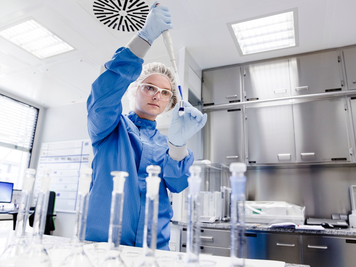 Cientistas trabalhando em um laboratório futurista, com elementos de interface de usuário de IA e diagramas de moléculas sobrepostos.