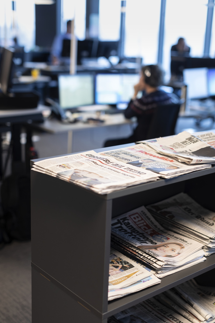 A collection of newspapers on a shelf in an office.