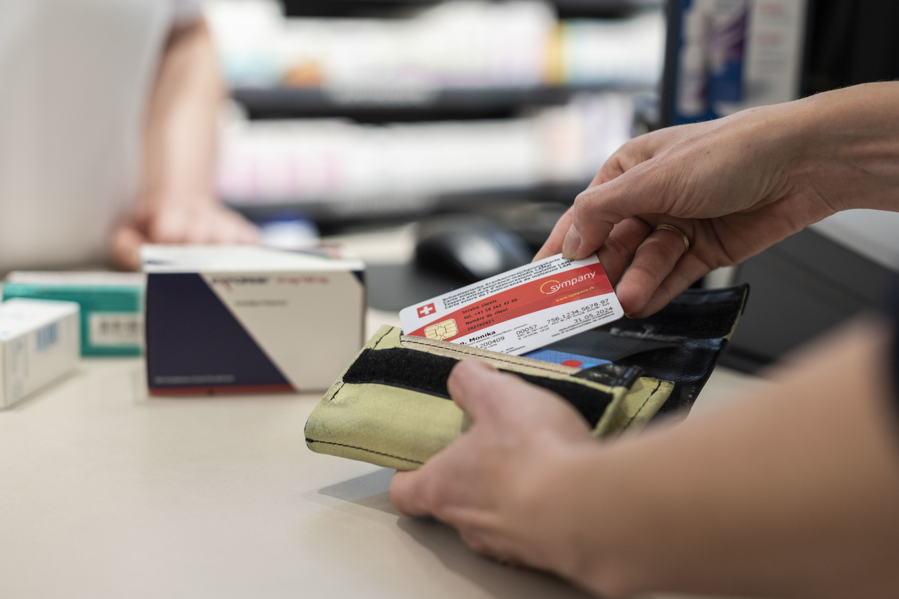 Main prenant une carte d'assurance maladie dans un portefeuille