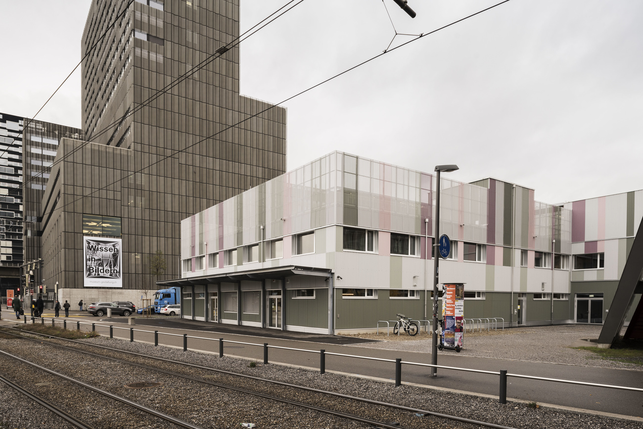 The exterior of the Federal Asylum Centre, a short, light-coloured building, in Zurich.