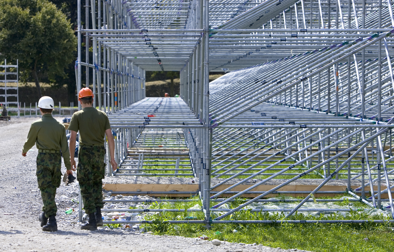 Two members of the Swiss armed forces work to dismantle scaffolding after the Swiss Wrestling and Alpine Festival in 2007.