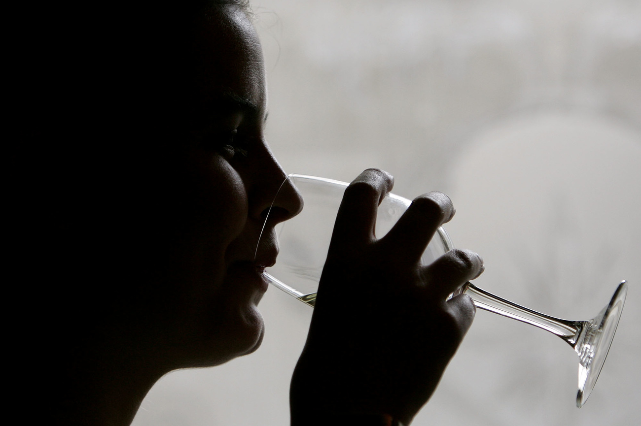 profilo di persona che beve un bicchiere di vino