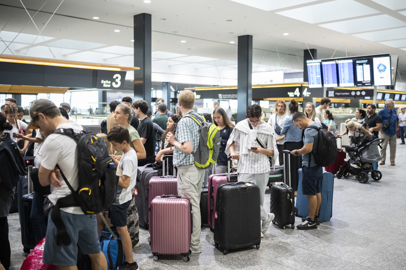 Persone in coda a uno sportello all'aeroporto di Zurigo.