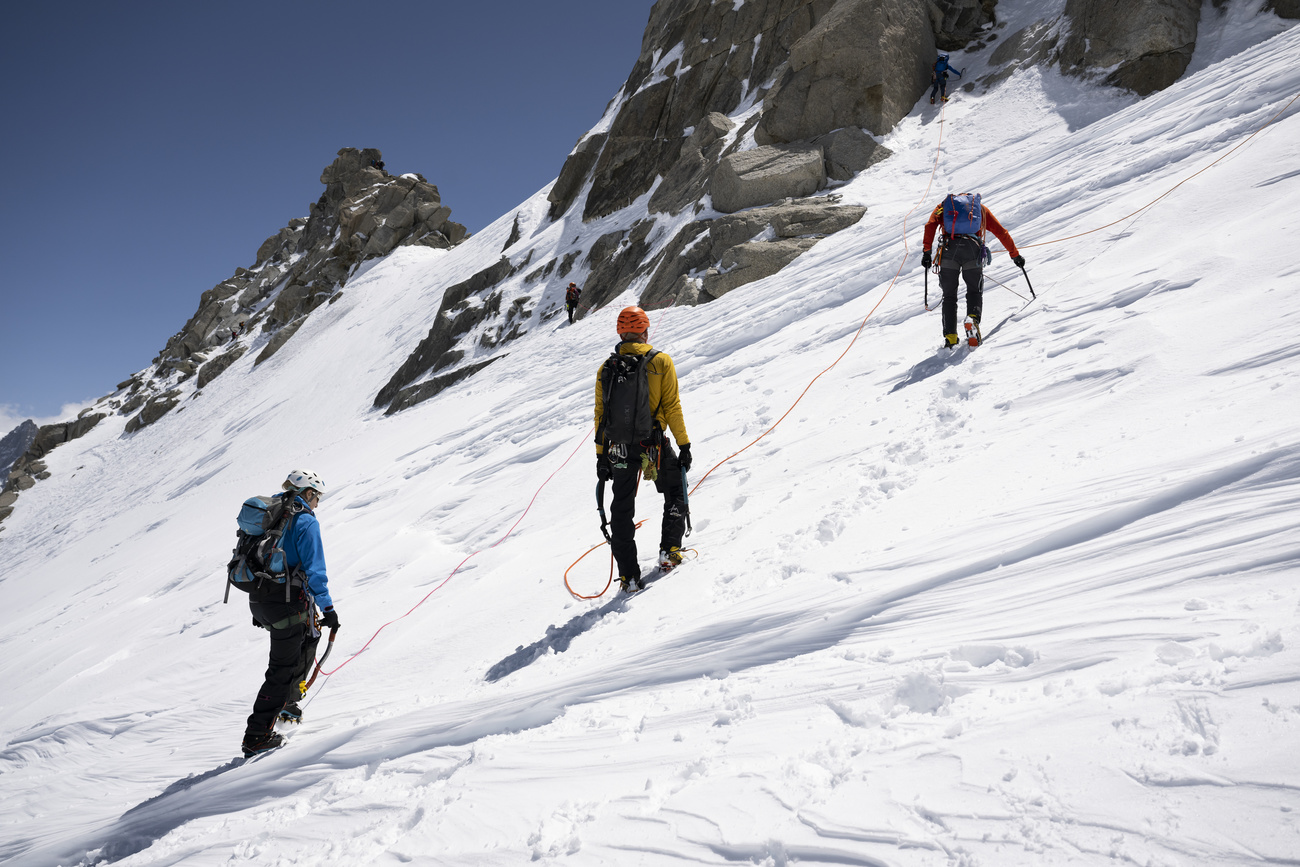 . An essential part of the alpinist mindset is the sense of team and community, which is represented by the rope connecting the alpinists to one another.
