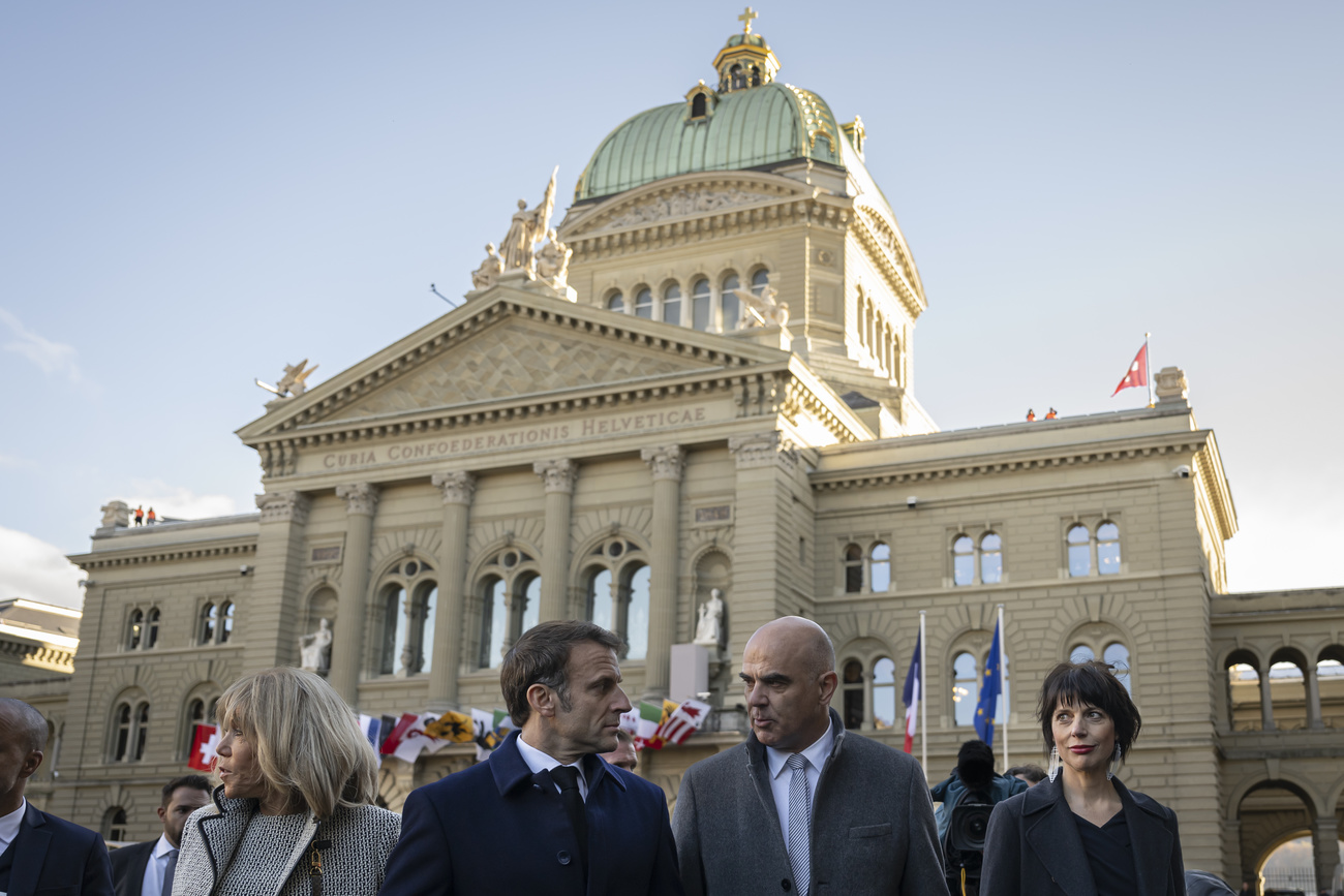 Президент Франции Эммануэль Макрон (в центре слева) с супругой Брижит Макрон (слева) и тогдашний президент Швейцарии Ален Берсе (в центре справа) с супругой Мюриэль Зендер Берсе (справа) Федеральным дворцом, зданием швейцарского парламента, в Берне, Швейцария, в среду, 15 ноября 2023 года.
