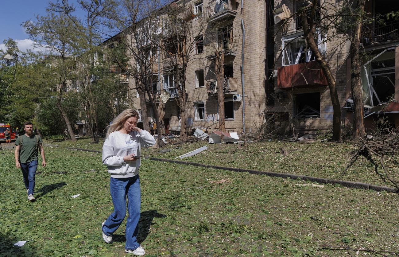 People walk past the scene of a Russian bomb attack on a residential building in Kharkiv, northeastern Ukraine, on May 5, 2024.