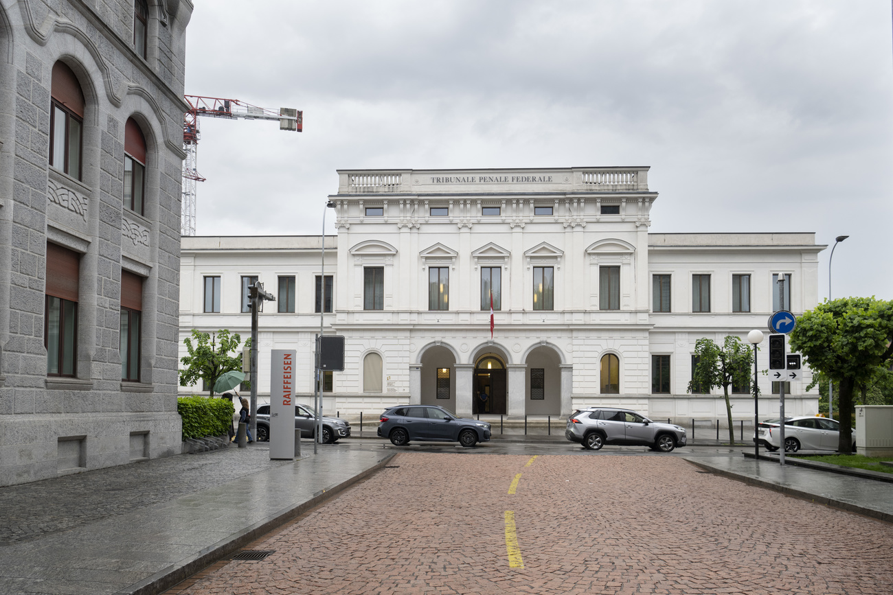 A large white building (the Swiss Federal Criminal Court) is shown from a distance.