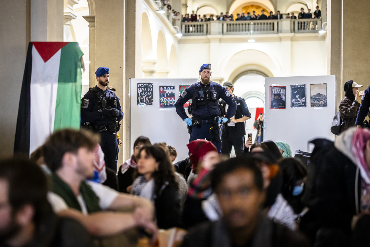 Police officers supervise Pro-Palestinian demonstrators during protest in the entrance hall of the main building of the ETH Zurich on Tuesday, May 7, 2024 in Zurich, Switzerland. (