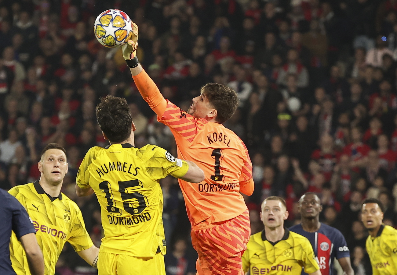 Swiss goalkeeper Gregor Kobel of Dortmund reaching for the ball with teammates nearby