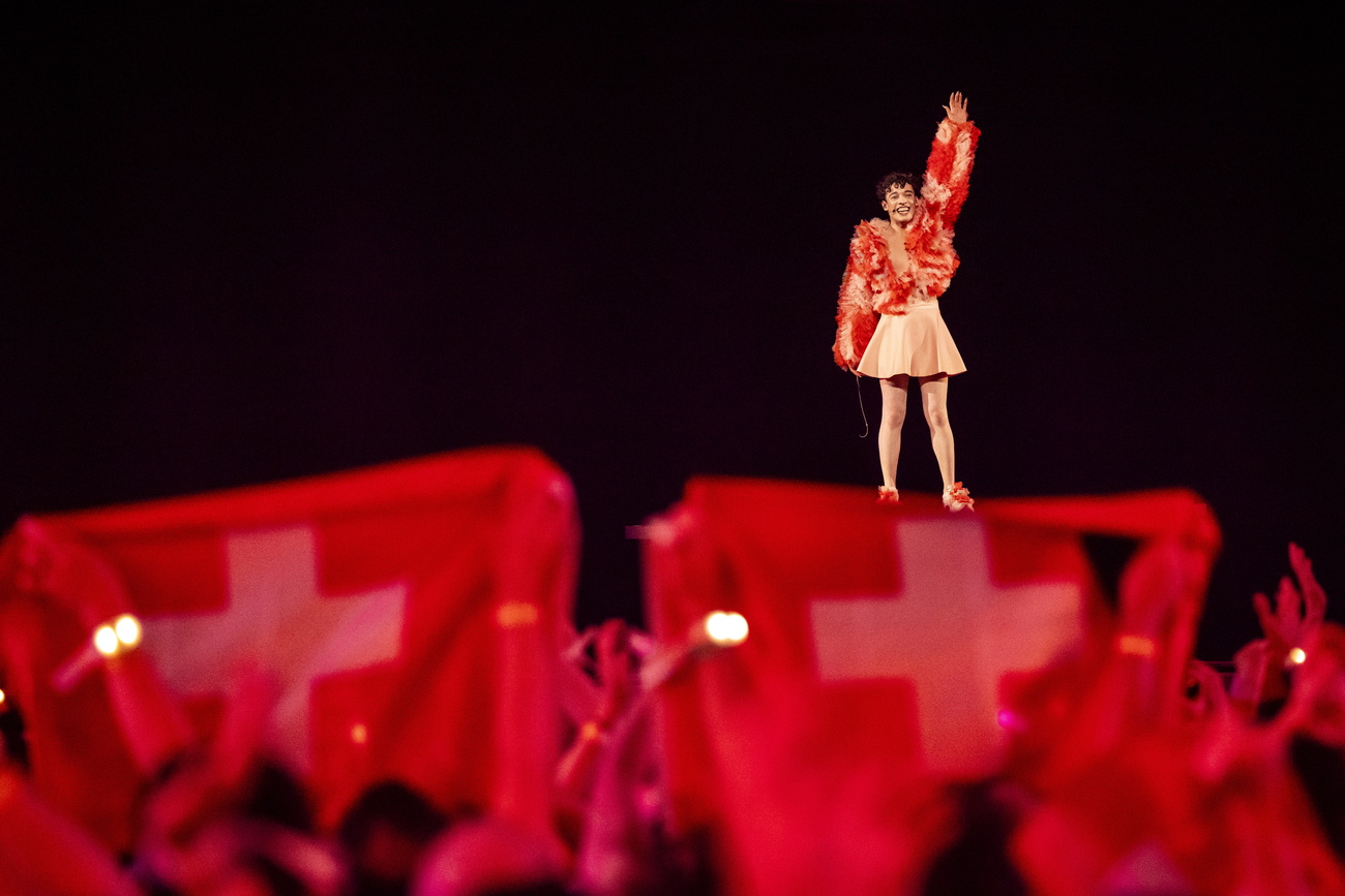 Nemo sur scène avec des drapeaux suisses