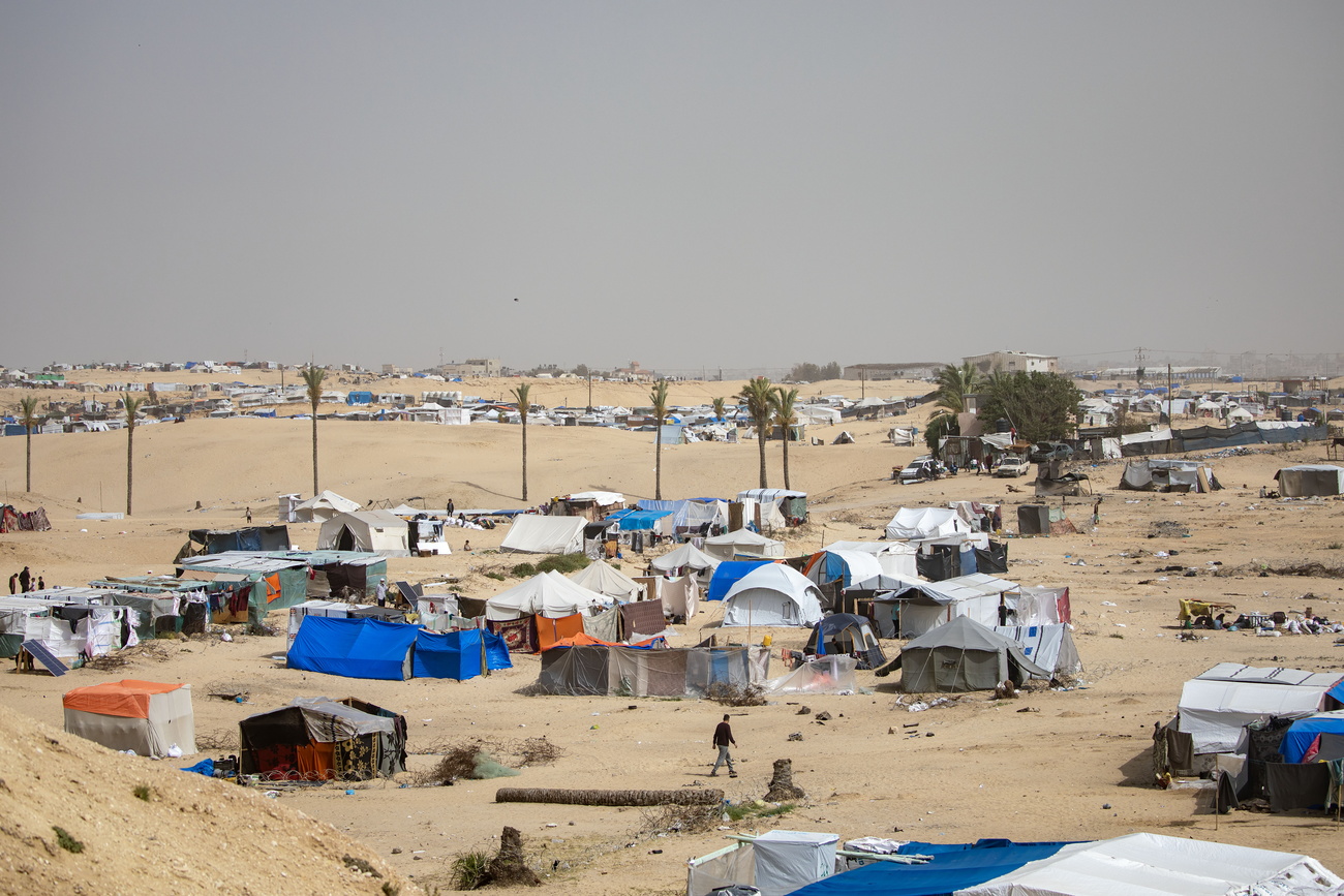 فلسطينيون.ات نازحون.ات داخليًا يستعدون.ن للمغادرة مع أمتعتهم.ن بعد أمر الإخلاء الذي أصدره الجيش الإسرائيلي، بالقرب من الحدود المصرية في رفح، جنوب قطاع غزة، يوم السبت.