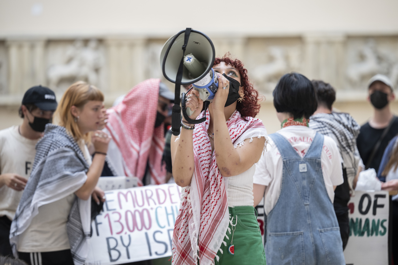 Eine Studentin mit einem Megaphon, mehr Leute im Hintergrund
