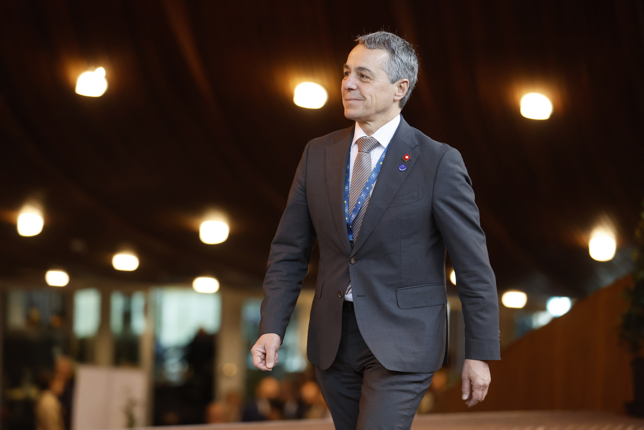 Swiss foreign minister Ignazio Cassis is shown walking outside of a large building.