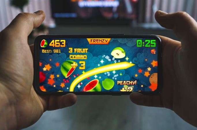 Jemand spielt Fruit Ninja auf einem Handy