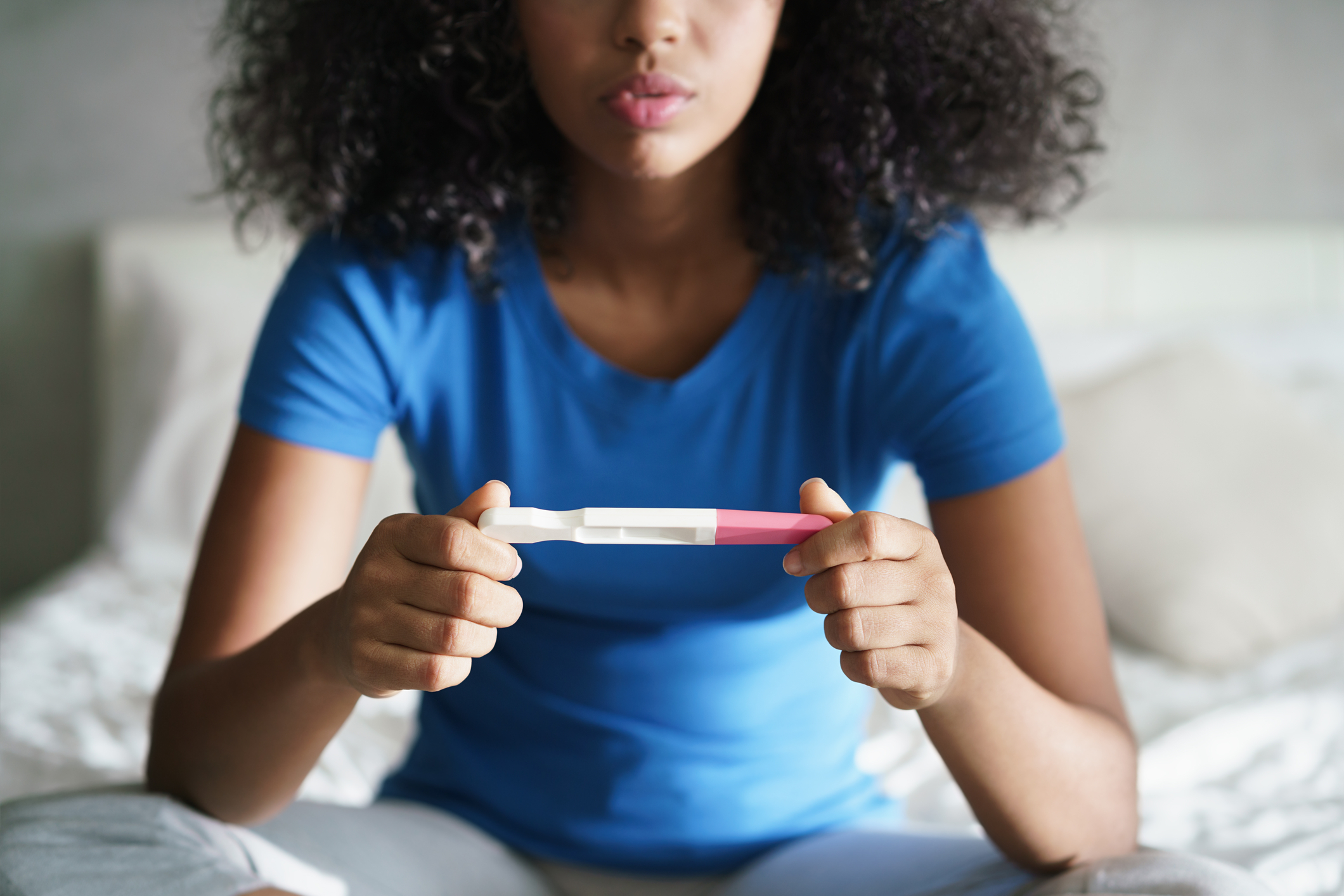 Eine Frau schaut einen Schwangerschaftstest an