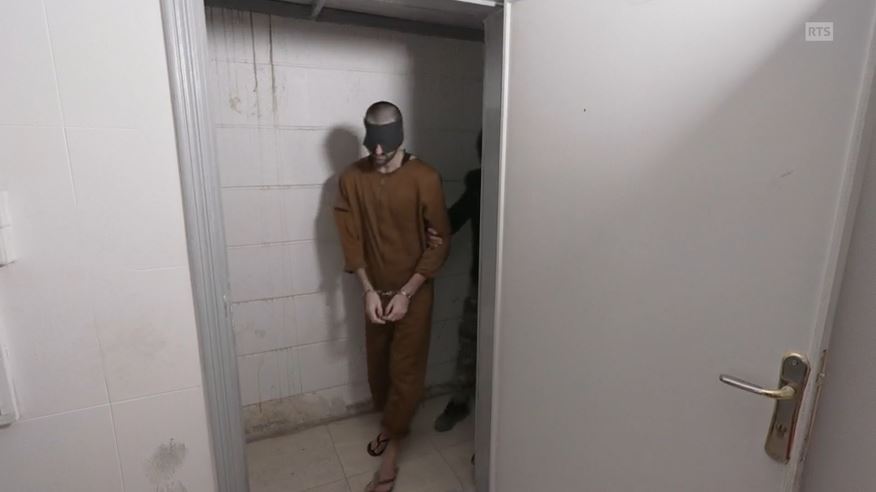Mann in Gefängniskleidung mit einer Augenbinde.