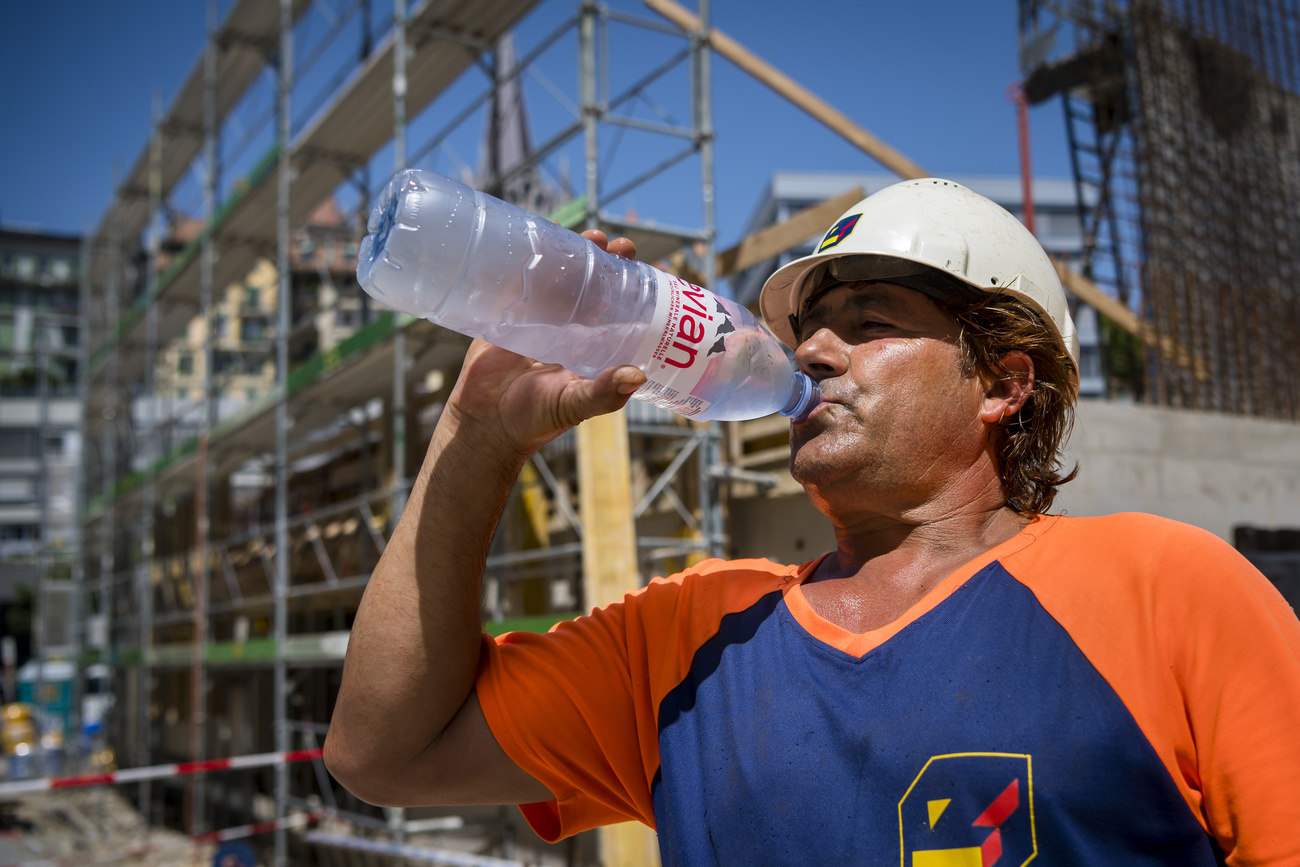 Operaio si disseta in un cantiere.