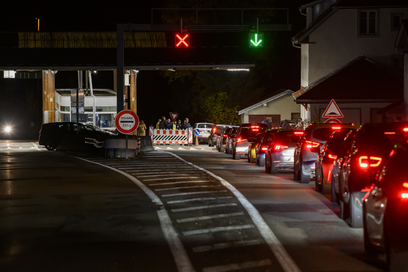 Lunga colonna di veicoli a un valico doganale elvetico.