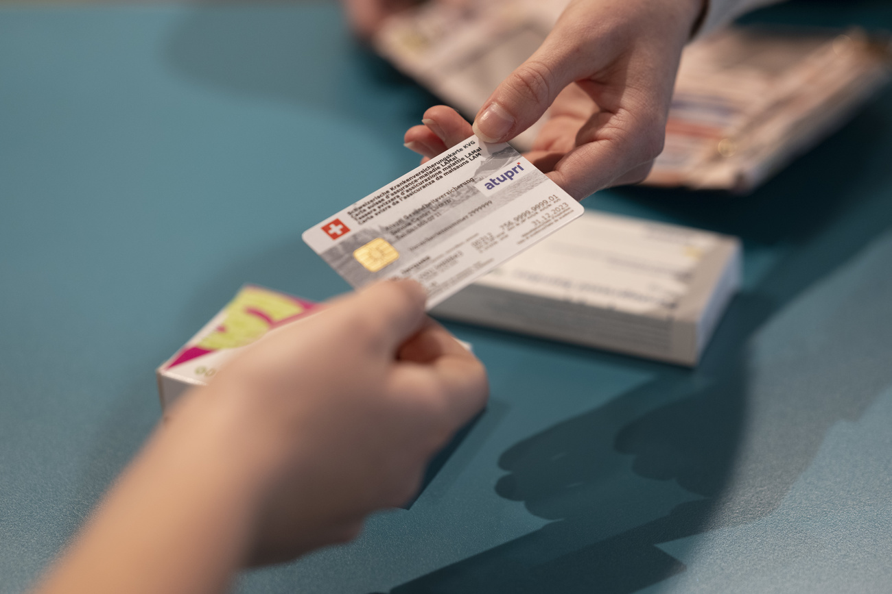 Zwei Hände an derselben Krankenkassenkarte.