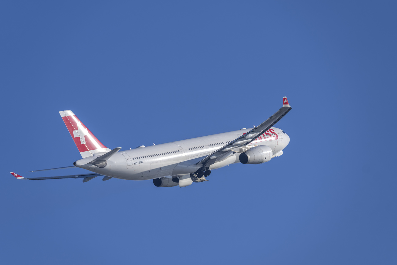 Ein Flugzeug der Swiss fliegt über den klaren Himmel.