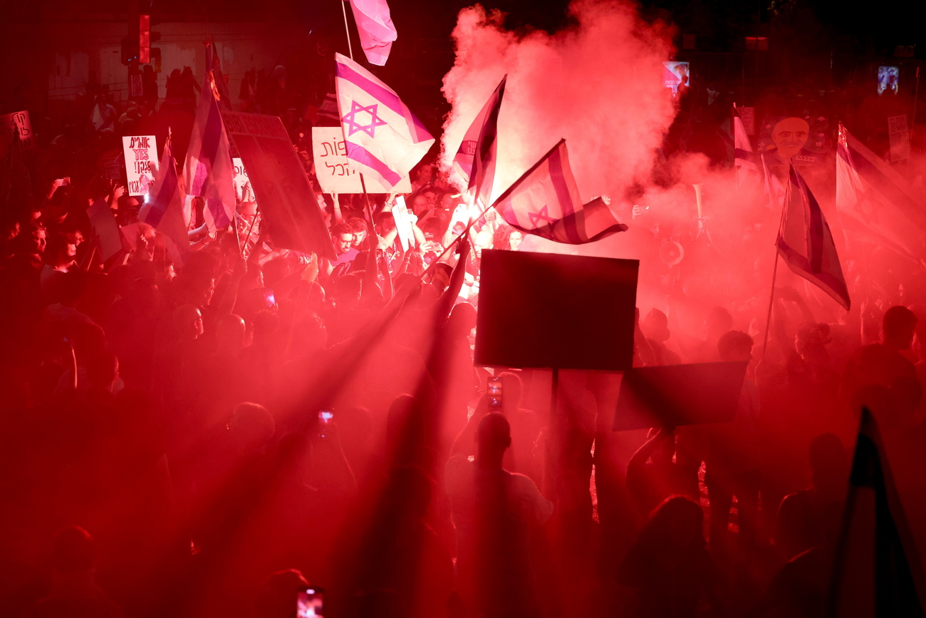 Protesters light flares as they take to the streets to call on the Israeli cabinet to sign a hostage deal and hold early elections during a demonstration in Tel Aviv, Israel, on June 1.