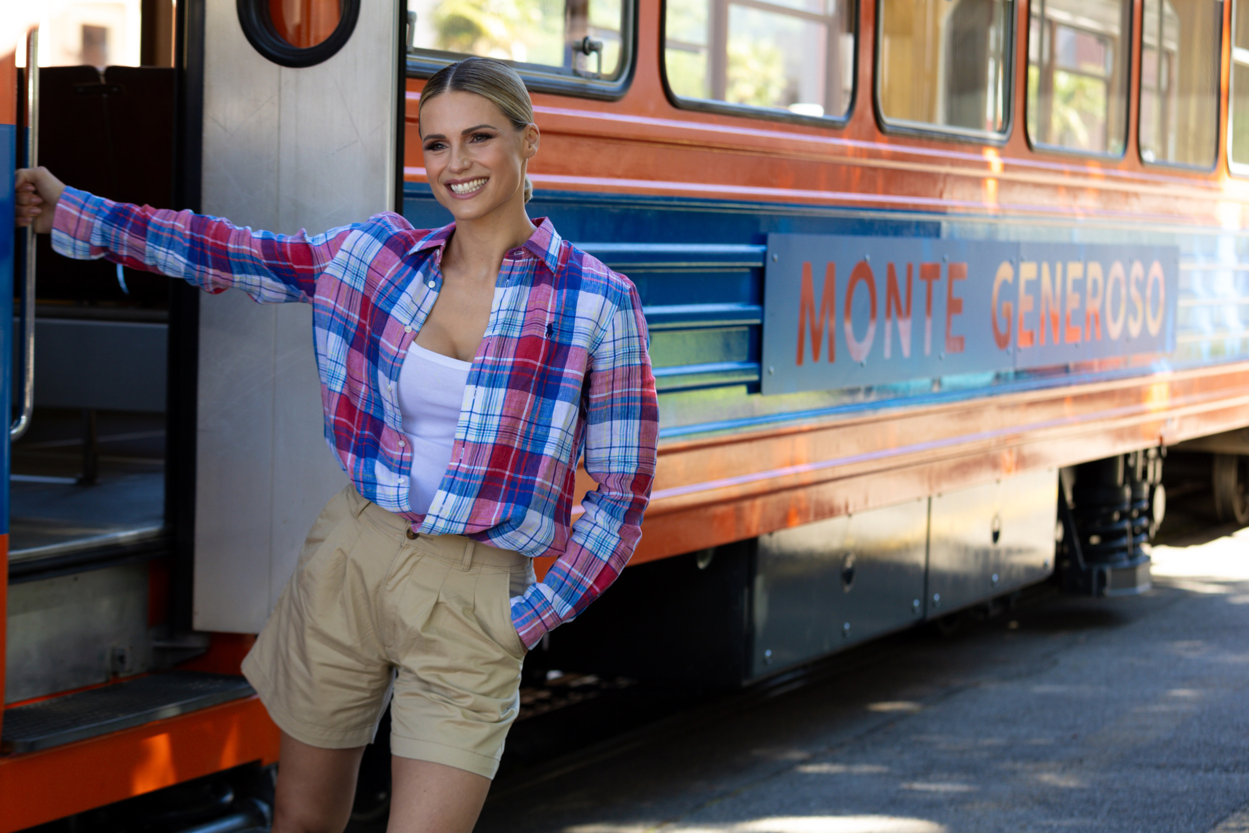 Michelle Hunziker di fianco al trenino a cremagliera che porta alla vetta del Monte Generoso.