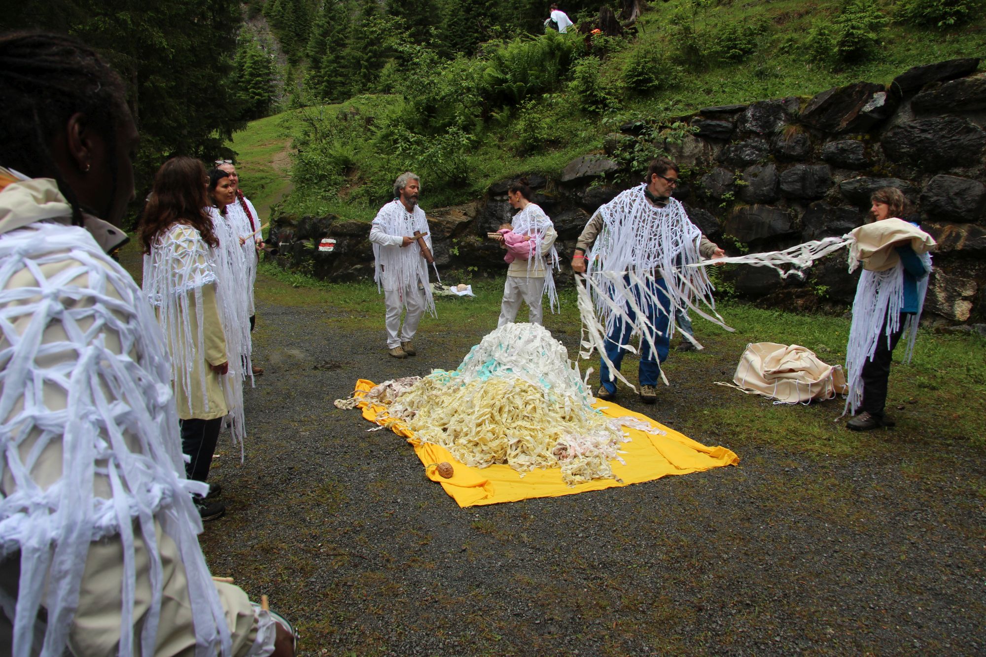 Ernesto Neto (back, centre) sank a sculpture he created last year in a ritual performance "Earth to Earth" at a place of power next to the mountain stream.