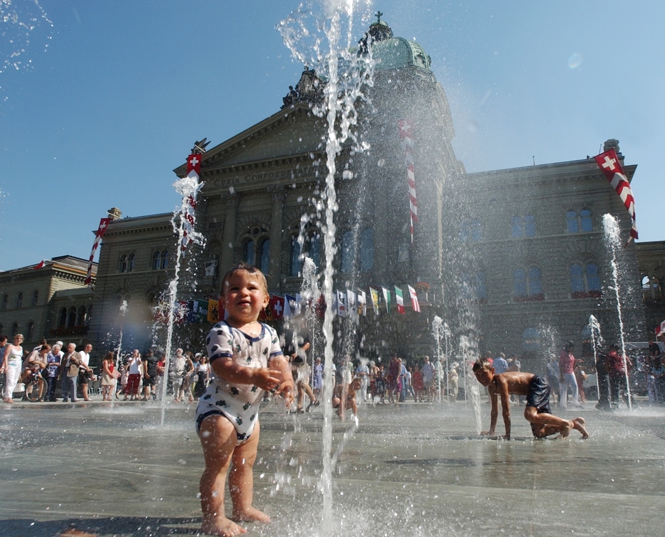 Kinder spielen am Wasserspiel vor dem Bundeshaus