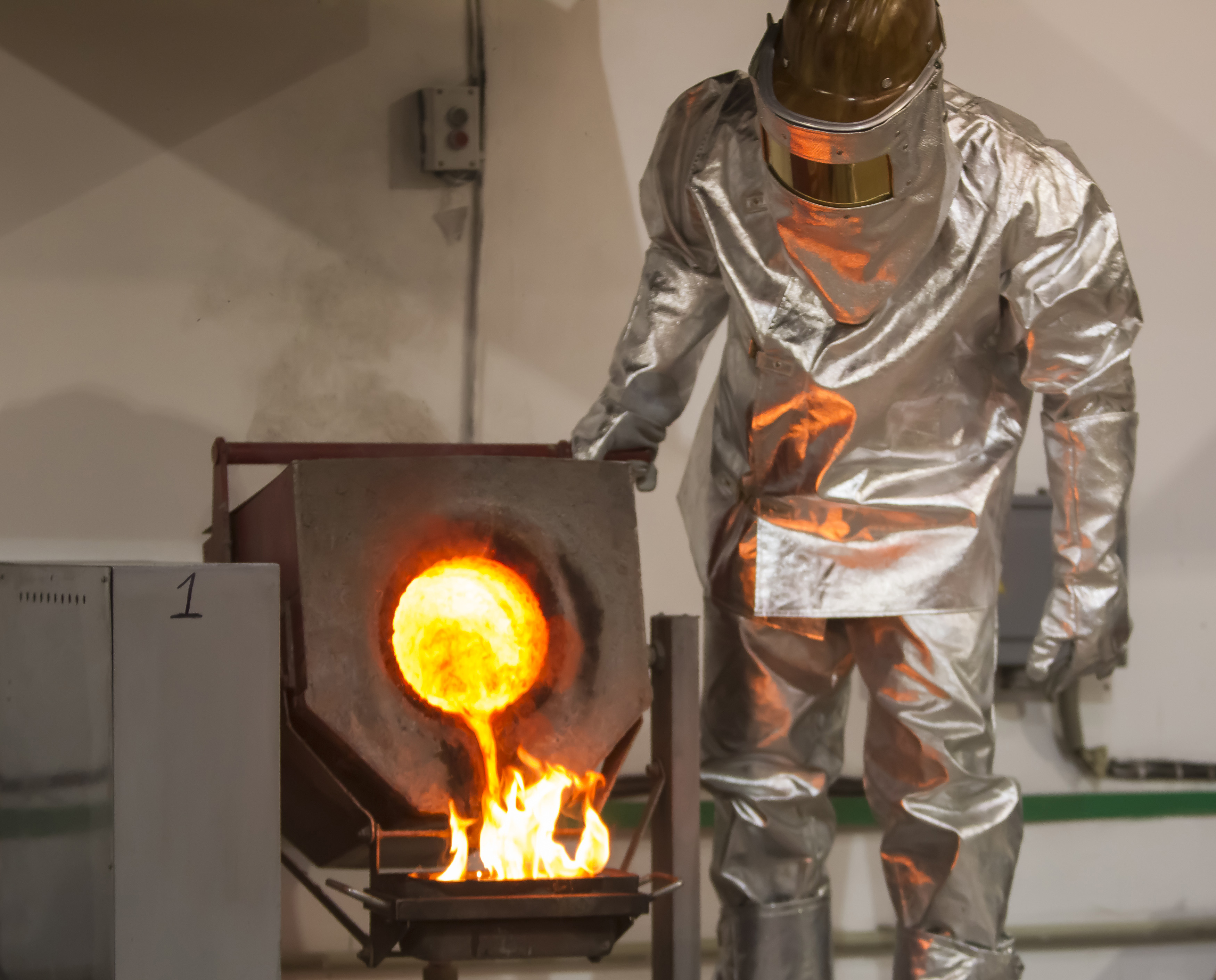 A worker wearing heatproof suit pours molten gold from a crucible into a mould in a workshop of Altyntau gold mine extraction factory outside northern Kazakhstan's town of Kokshetau