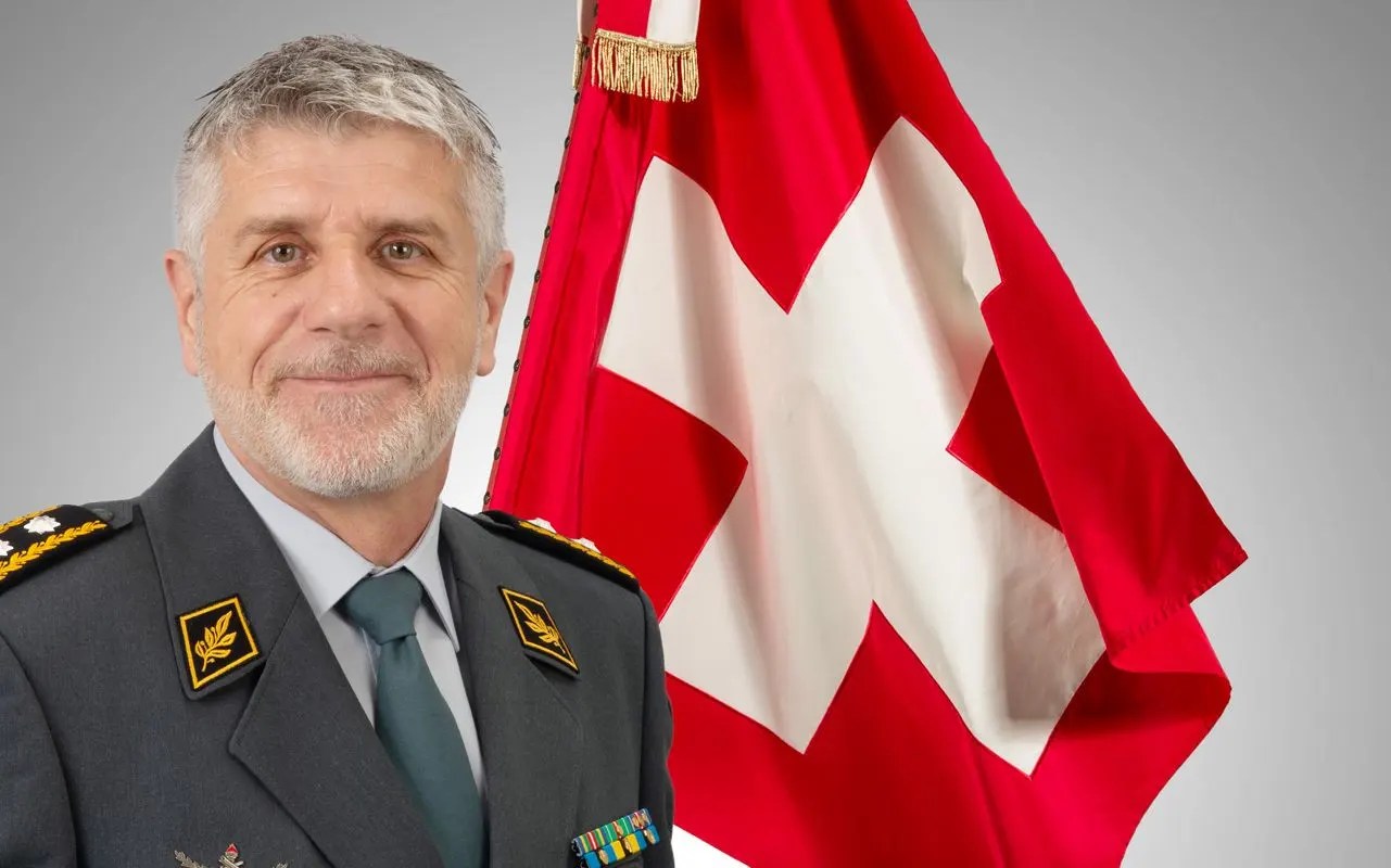 Divisionär Guy Vallat vor der Schweizer Fahne.