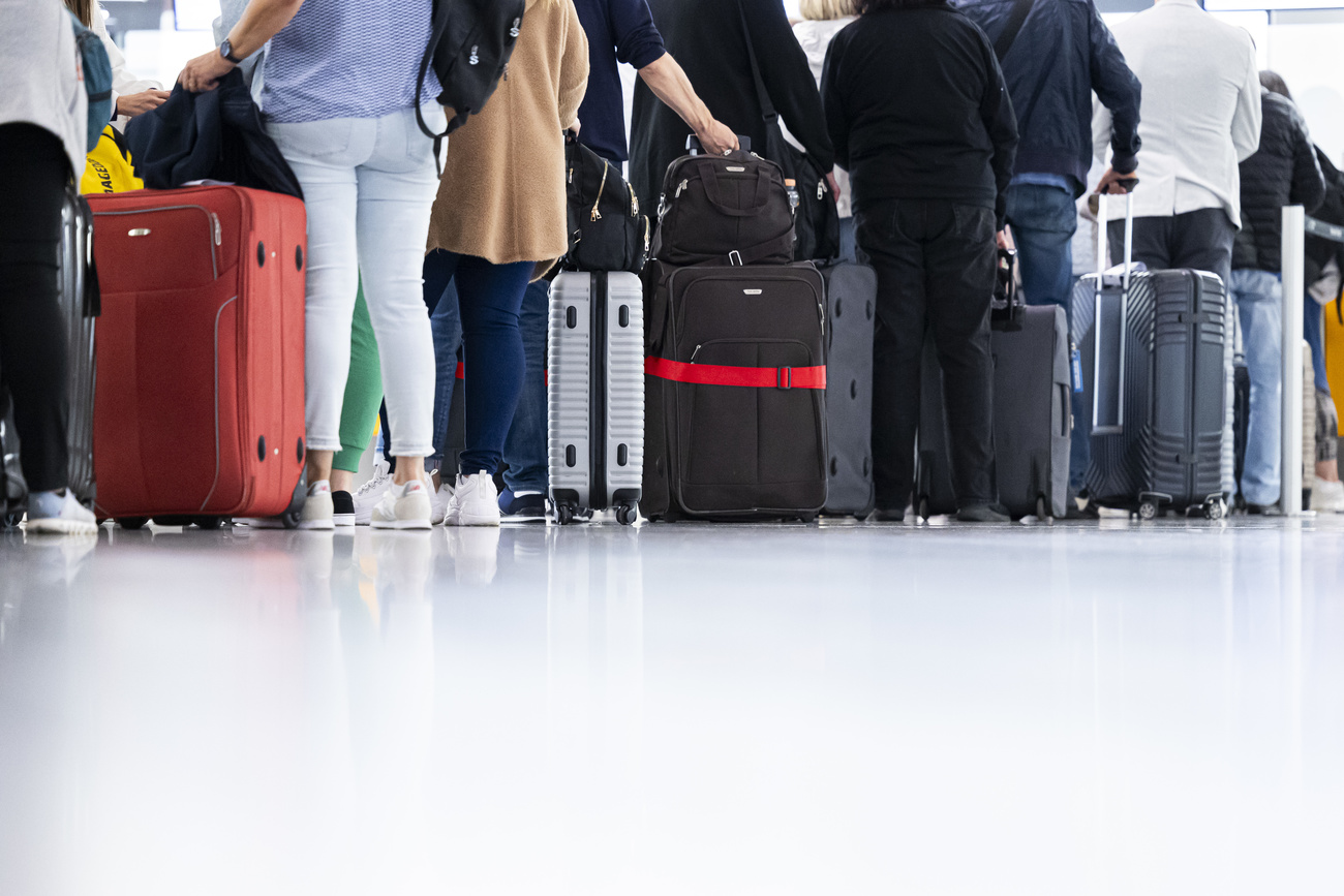 File de touristes avec des valises