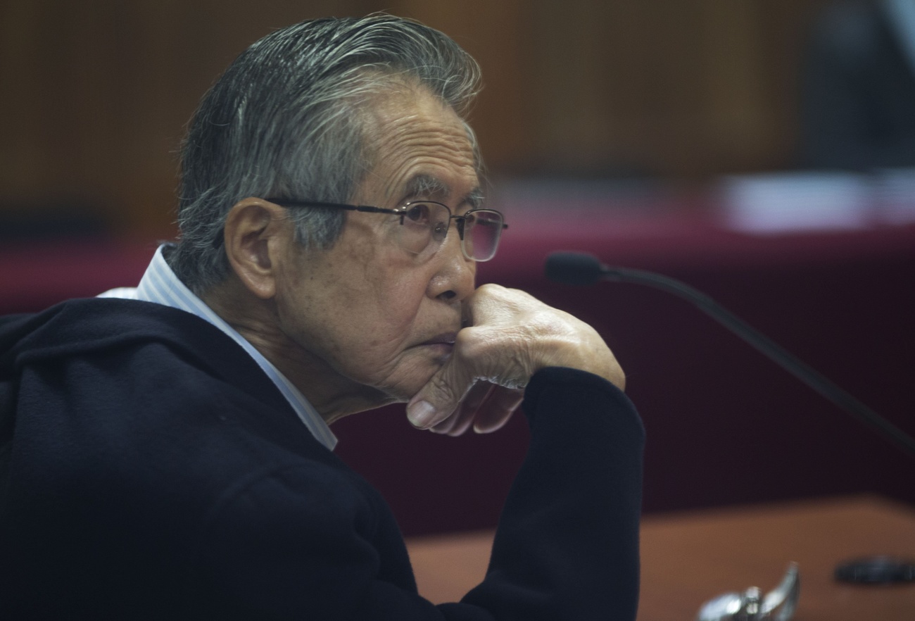 El encarcelado ex presidente de Perú, Alberto Fujimori, fotografiado a través de una ventana de vidrio, asiste a su juicio en una base policial en las afueras de Lima, Perú, el 28 de junio de 2016.