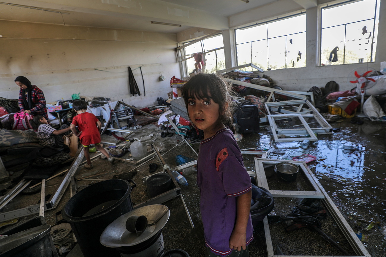 فتاة فلسطينية تتفقد مدرسة تابعة للأونروا تعرضت لأضرار جراء غارة جوية إسرائيلية في مخيم النصيرات للاجئين بوسط قطاع غزة، 14 يوليو 2024.