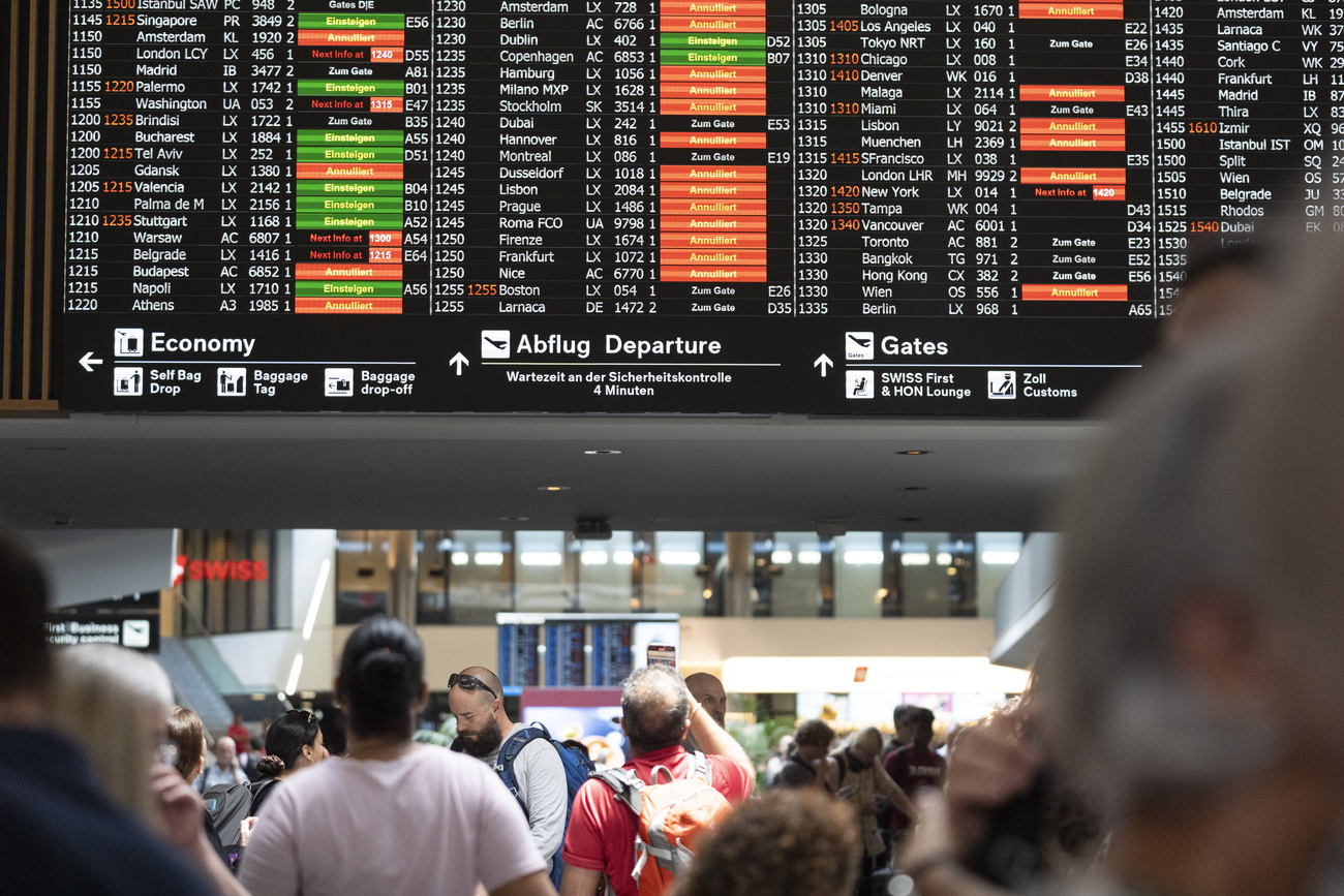 zurich airport flight schedule shows cancelled and delayed flights. Travellers look at the flight schedule.