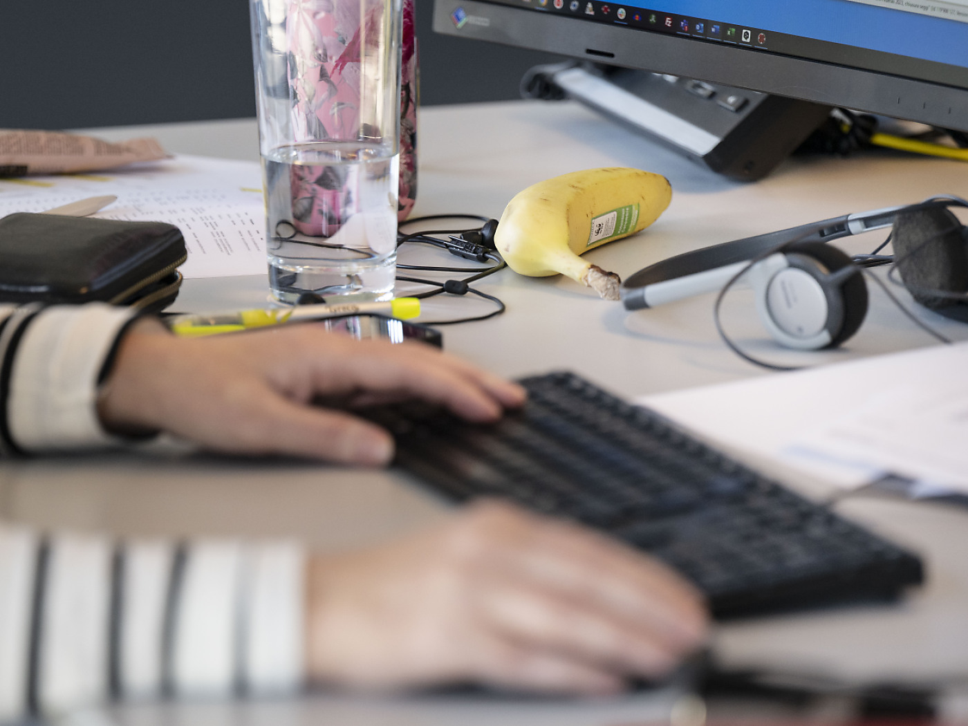 Picture of a person's hands on a keyboard on a desk