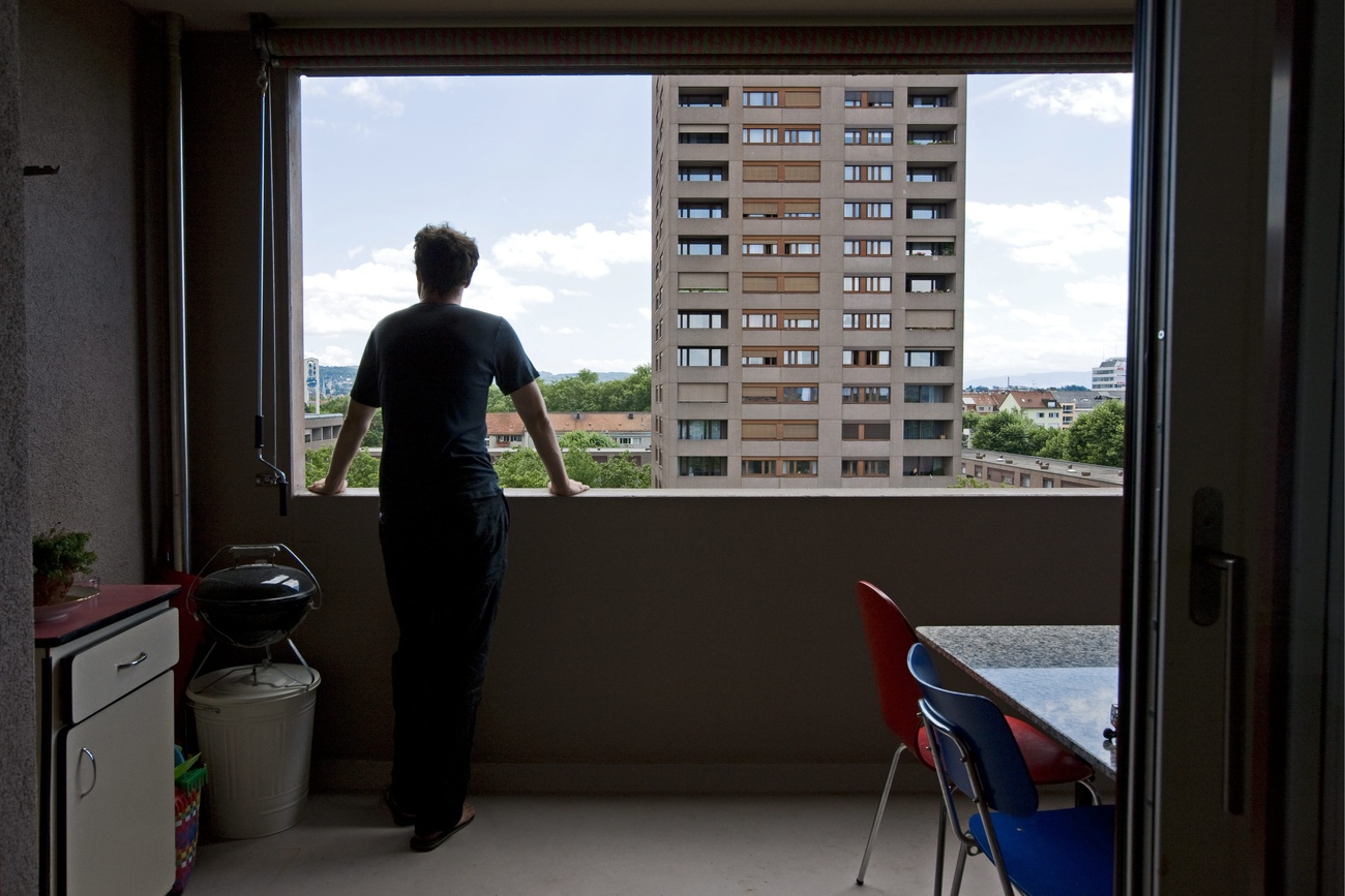 Personne regardant une tour d'habitation depuis une fenêtre