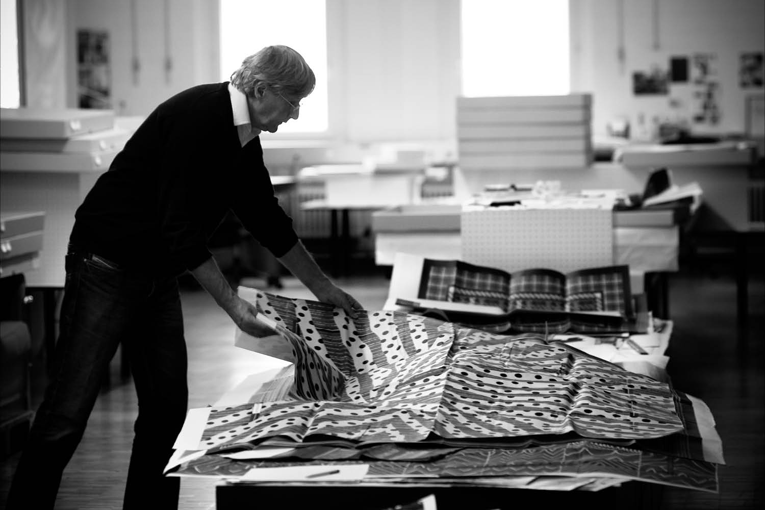 Erich Biehle looks at sketches in his studio.