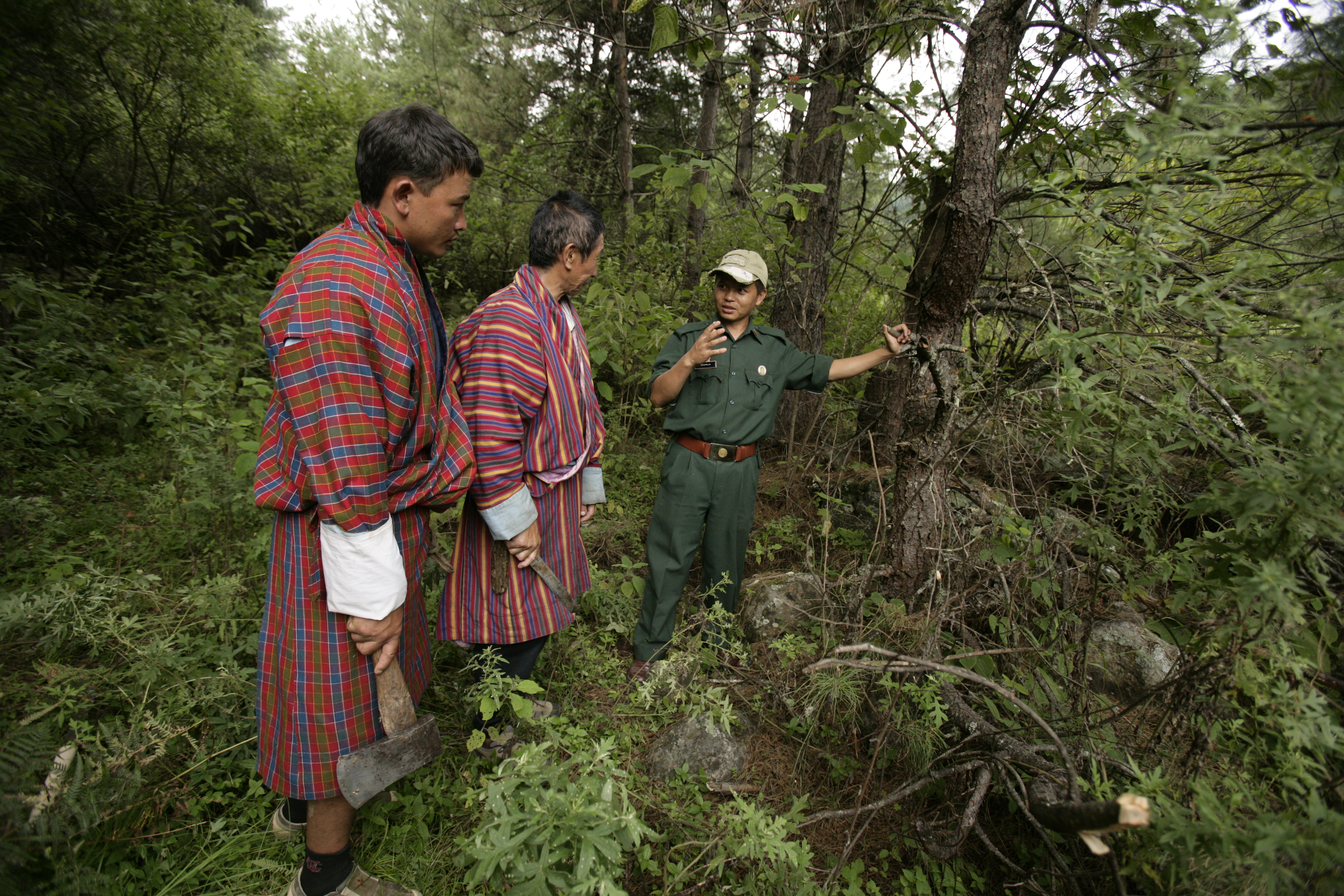 Tre persone abitanti del Bhutan in una foresta