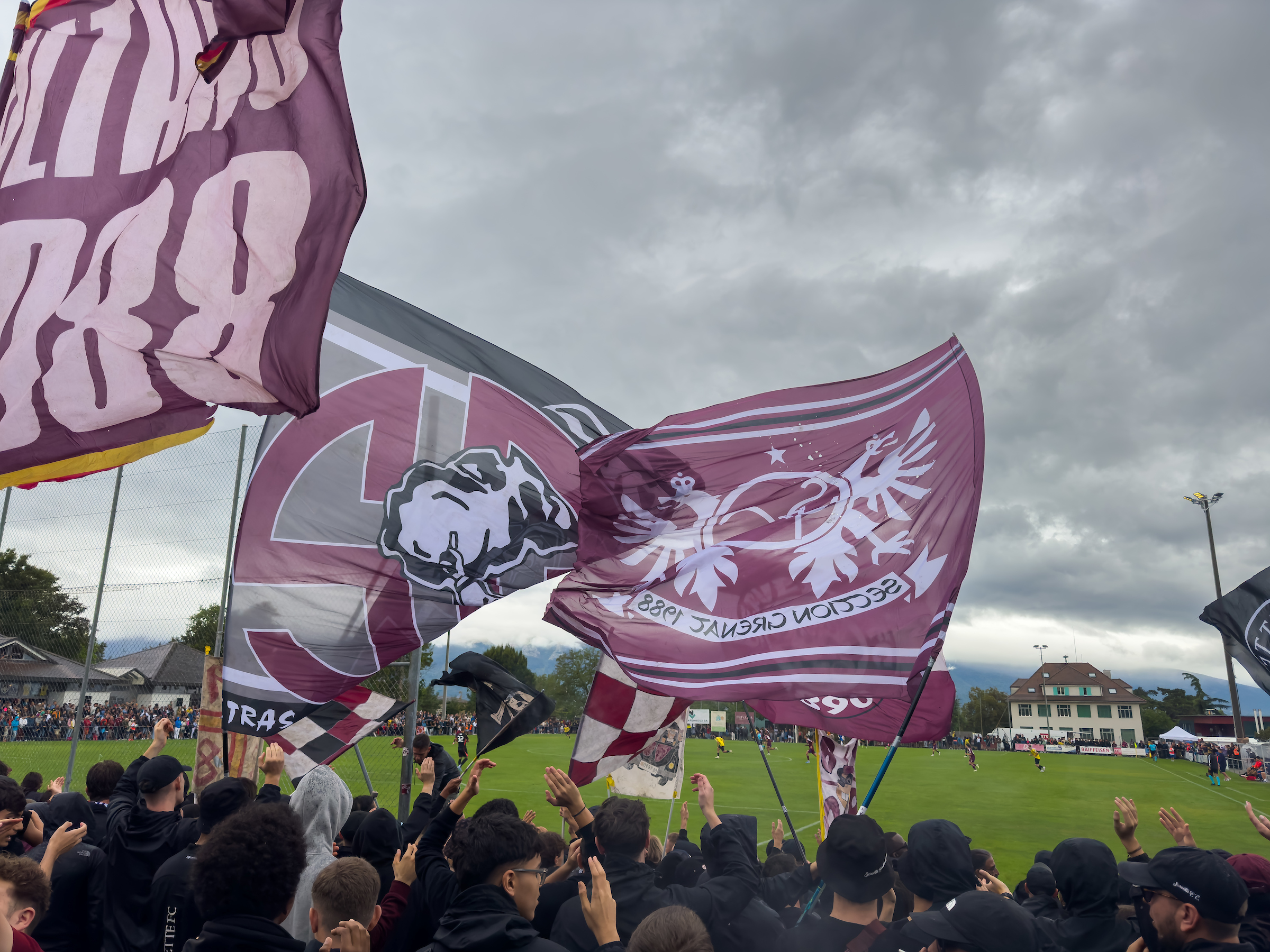 tifosi e tifose sventolano le bandiere mentre assistono a una partita di calcio