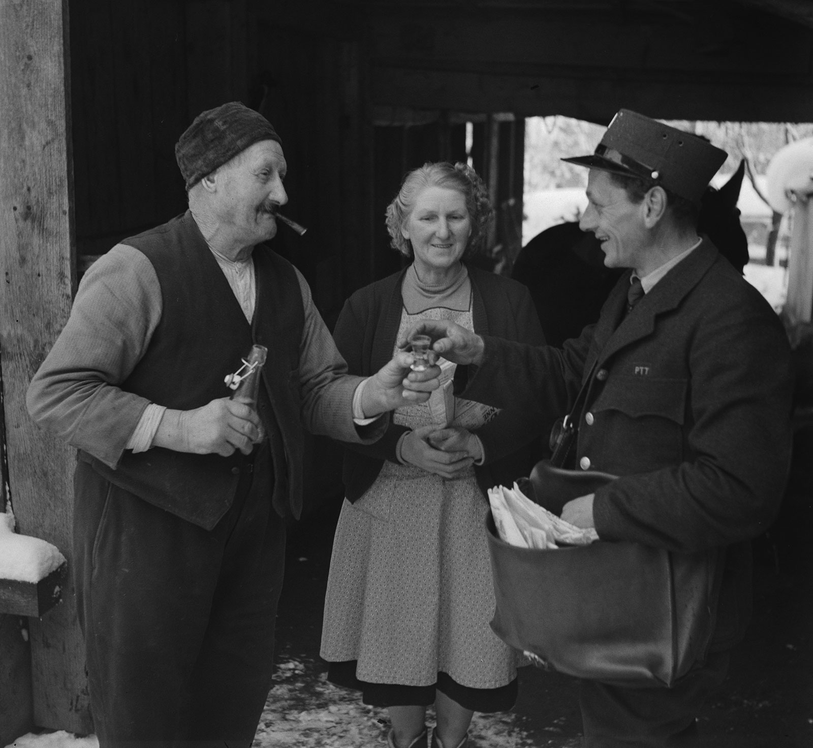 old photo of a postman receiving the offer of a schnapps