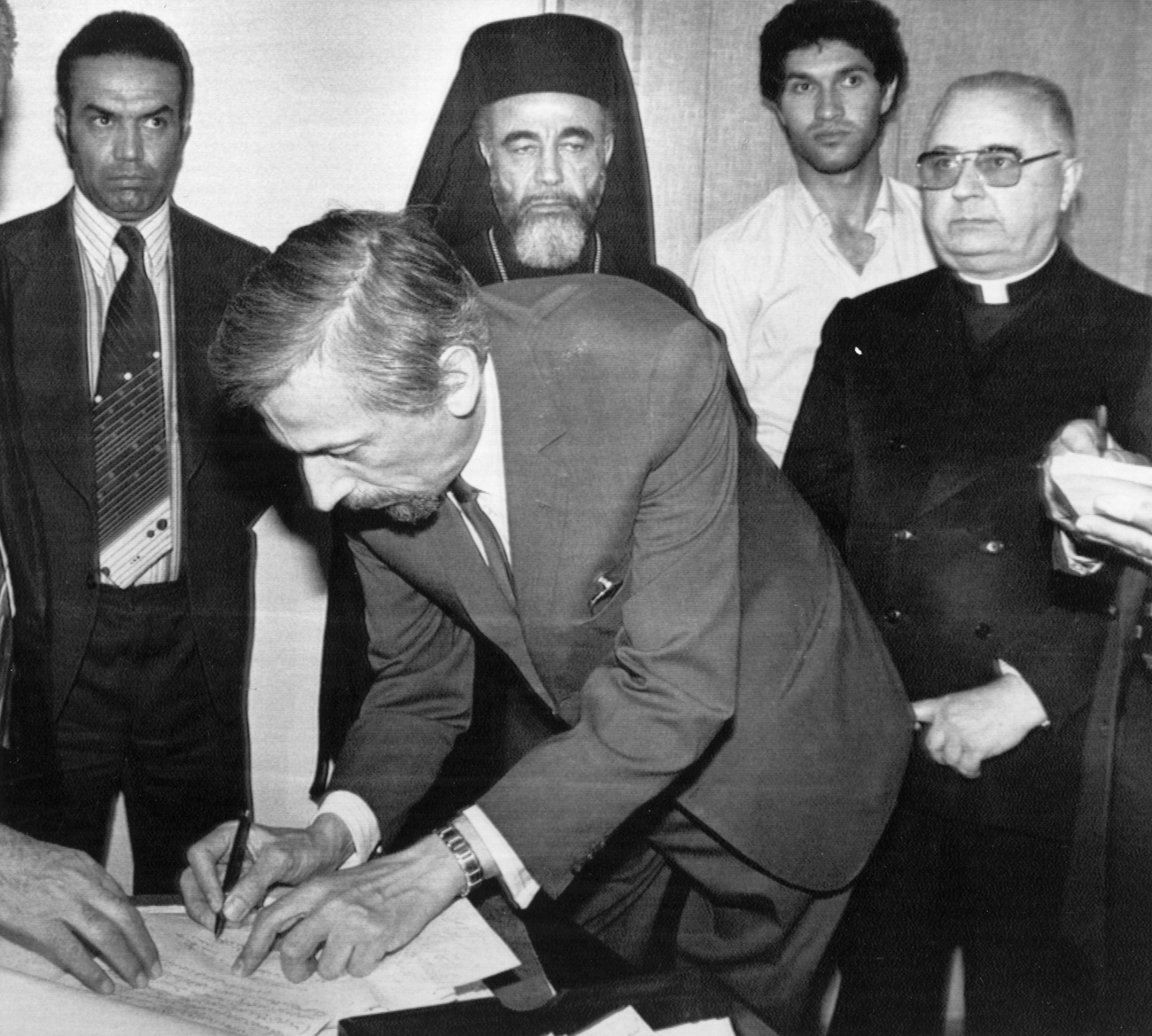 un uomo firma un documento su un tavolo