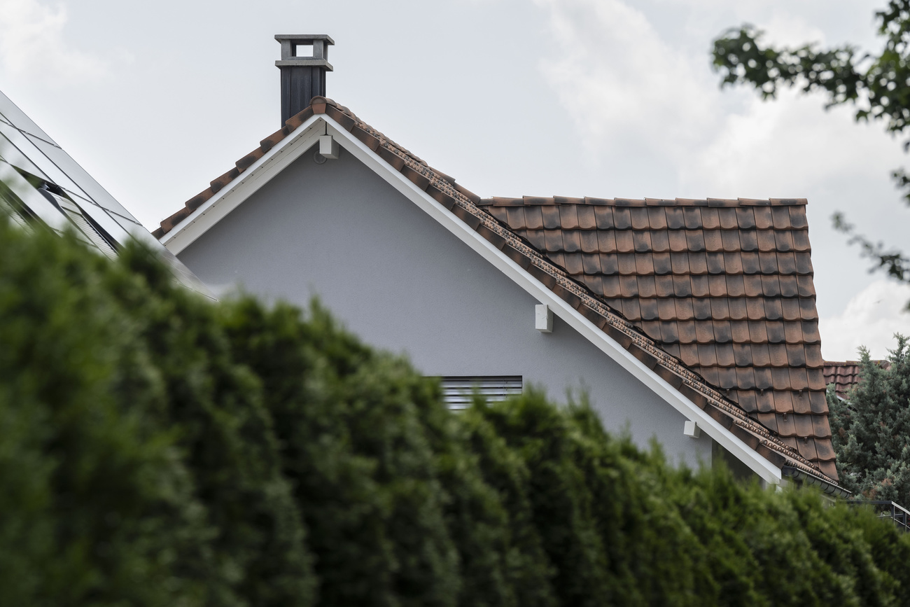 ein Einfamilienhaus hinter eine Hecke