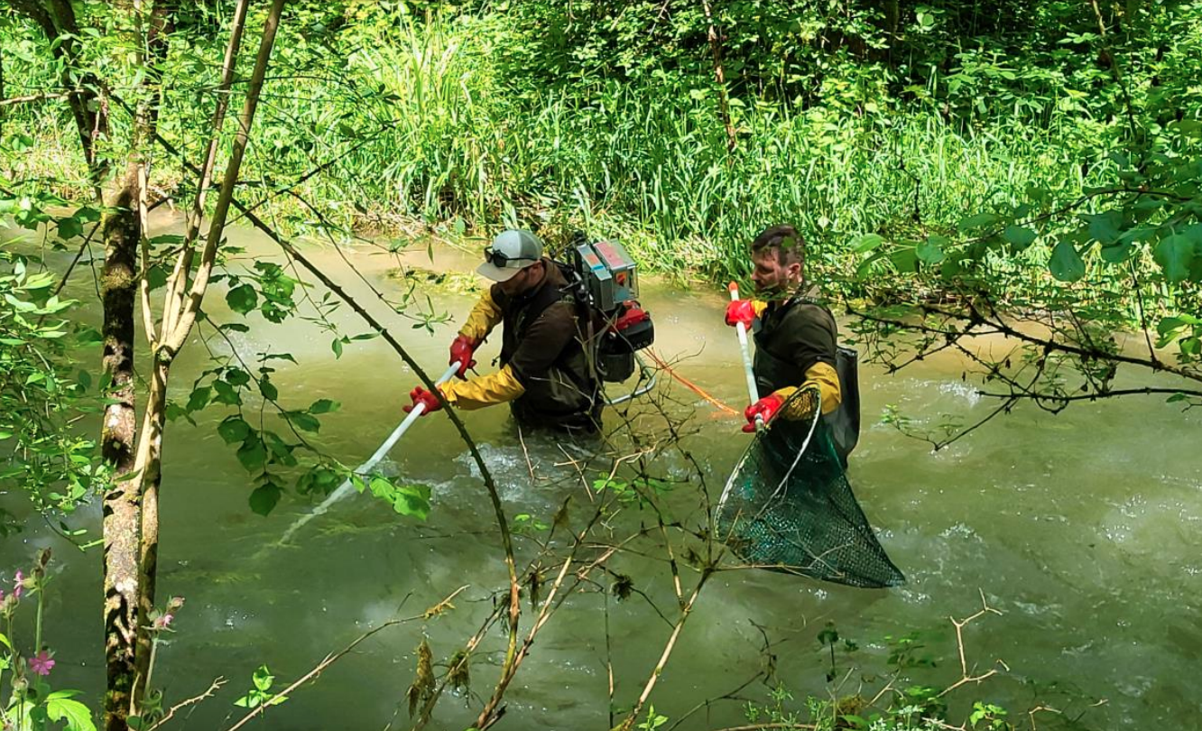 due persone in piedi in mezzo a un corso d'acqua