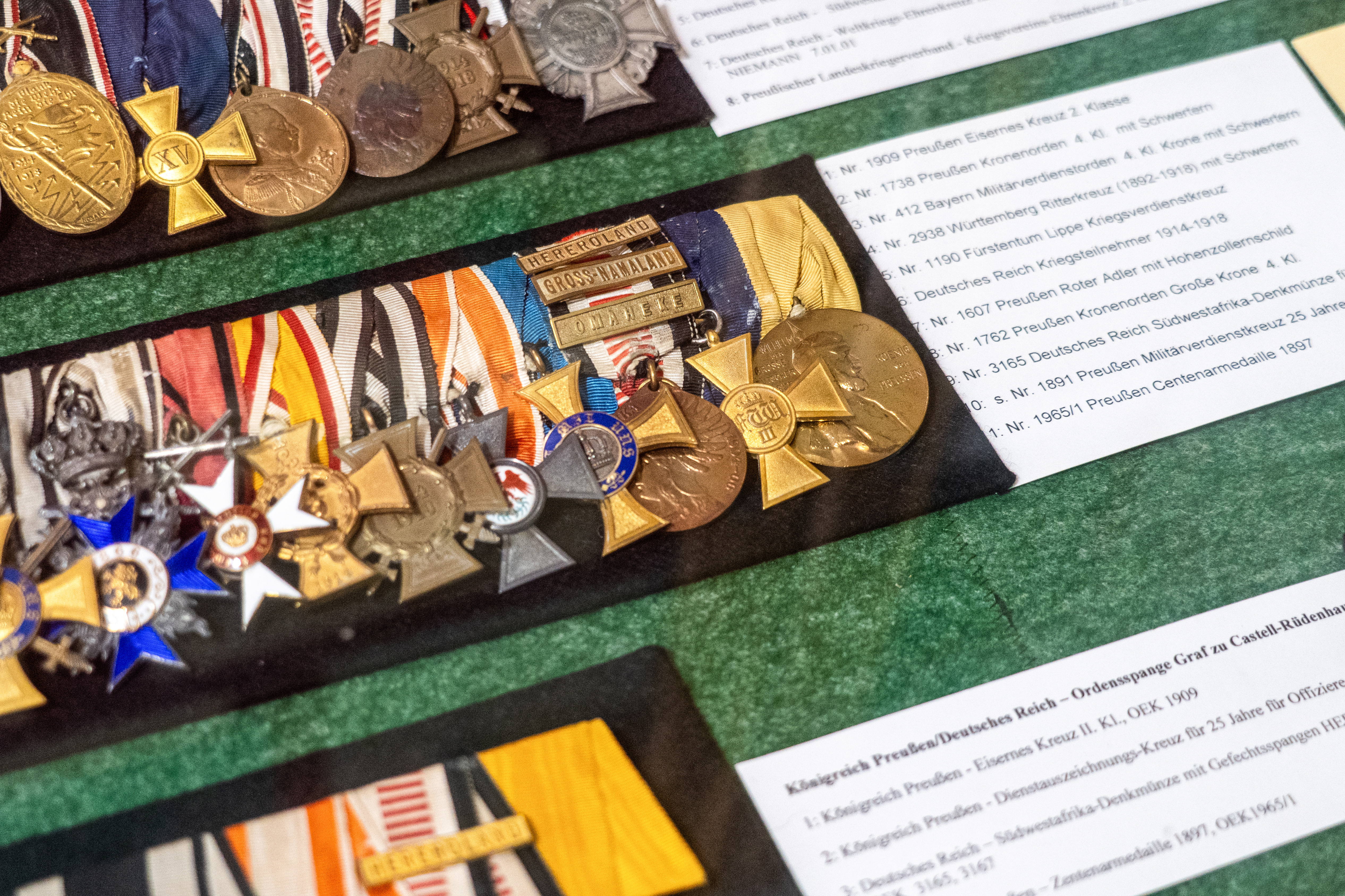 View of a display case at a local history museum which is full of German military uniforms, insignia and weapons.