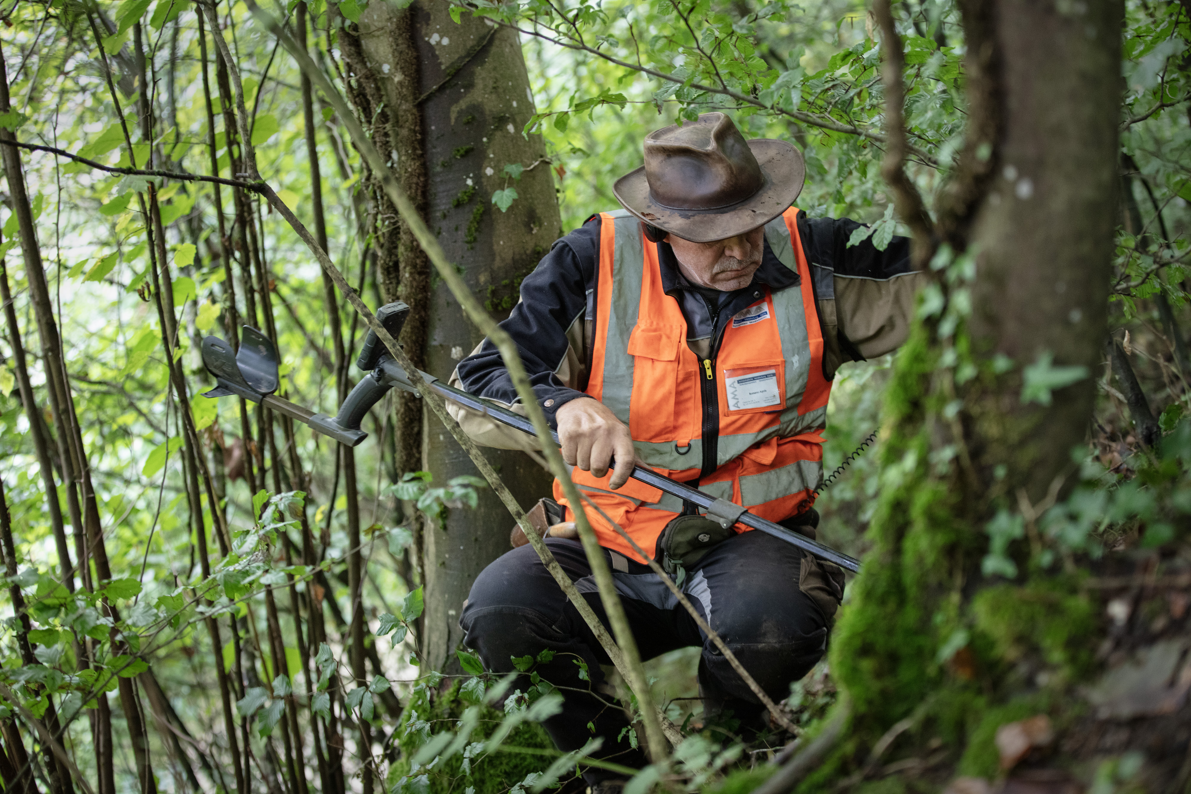 Ein Mann sucht etwas im Wald