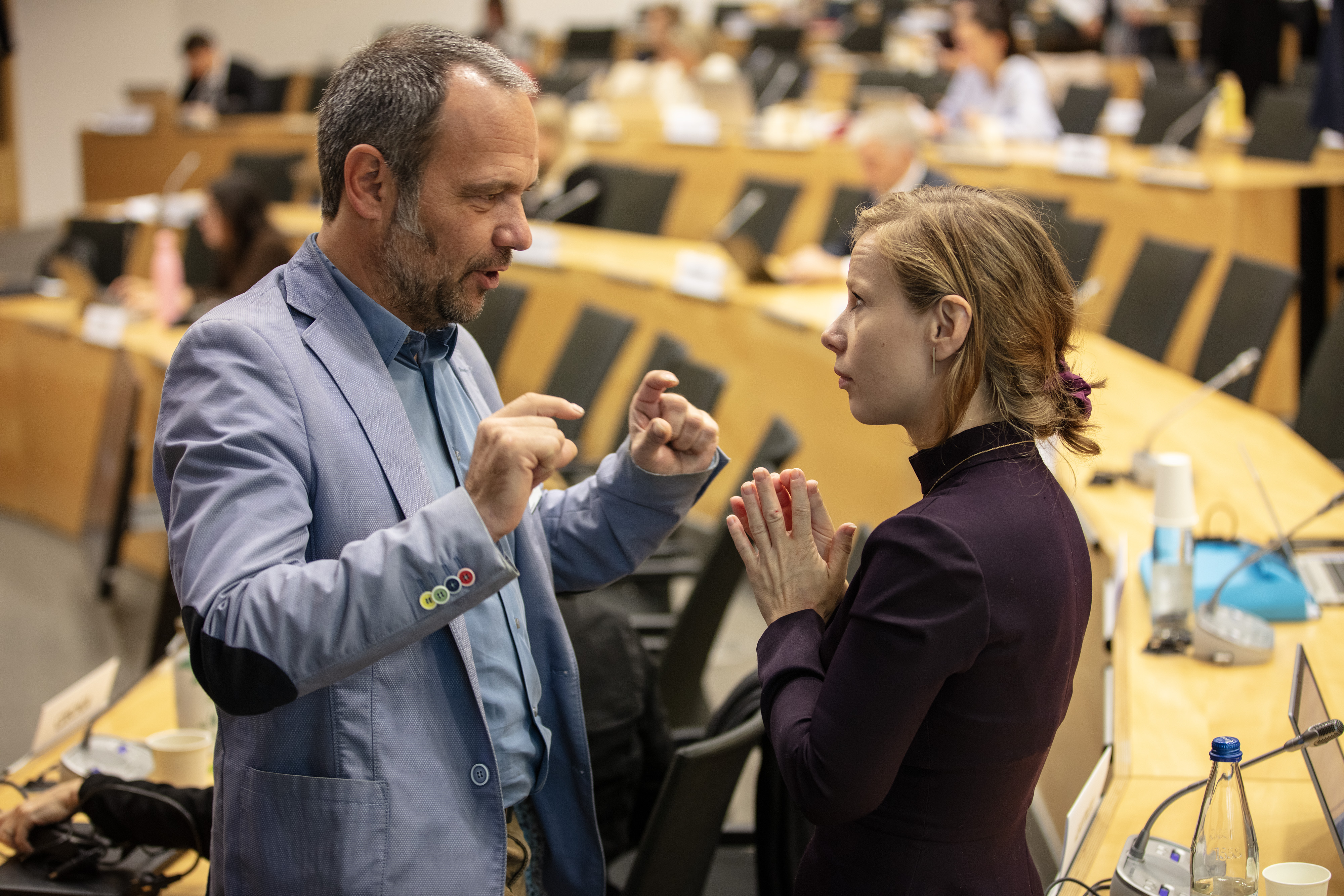 Thomas Schneider working during a break. Here he talks with Monica Hanych, a delegate from the Czech Repubilc.