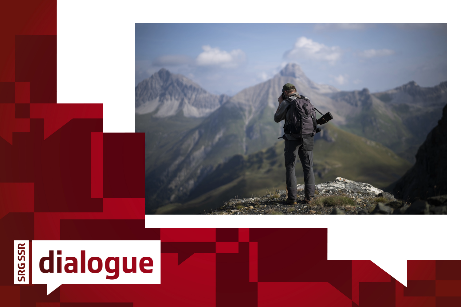 A hunter stands on top of a mountain.